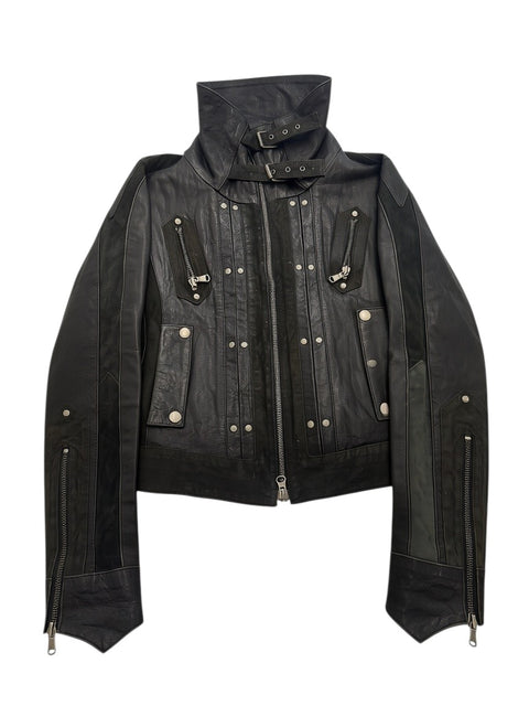 CHEZ SNOW BUNNY GDOS black leather jacket with high neck, buckle straps, silver hardware, and zippered pockets.