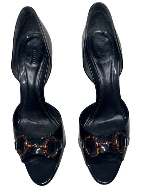 CHEZ SNOW BUNNY Gucci black leather peep-toe heels featuring a tortoiseshell horsebit detail on a white background